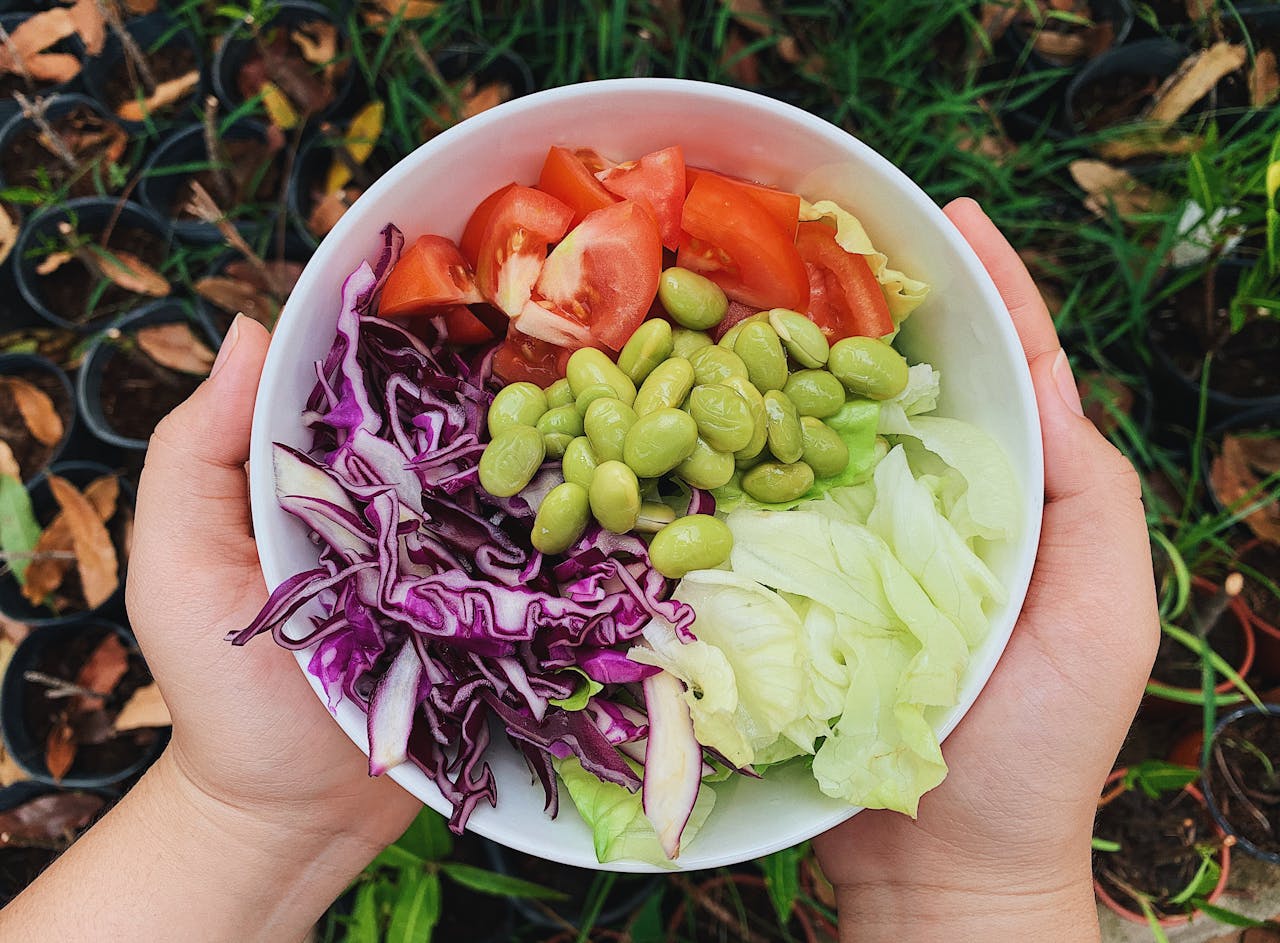 A vibrant bowl of fresh garden salad featuring tomatoes, edamame, and cabbage. Perfect for healthy dining.